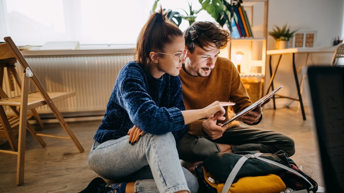 Homme et femme regardant une tablette, renouvelant leur hypothèque.