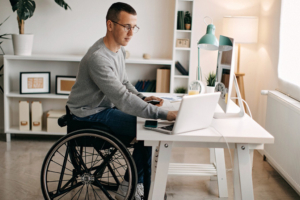 Un jeune homme en fauteuil roulant travaille à domicile.