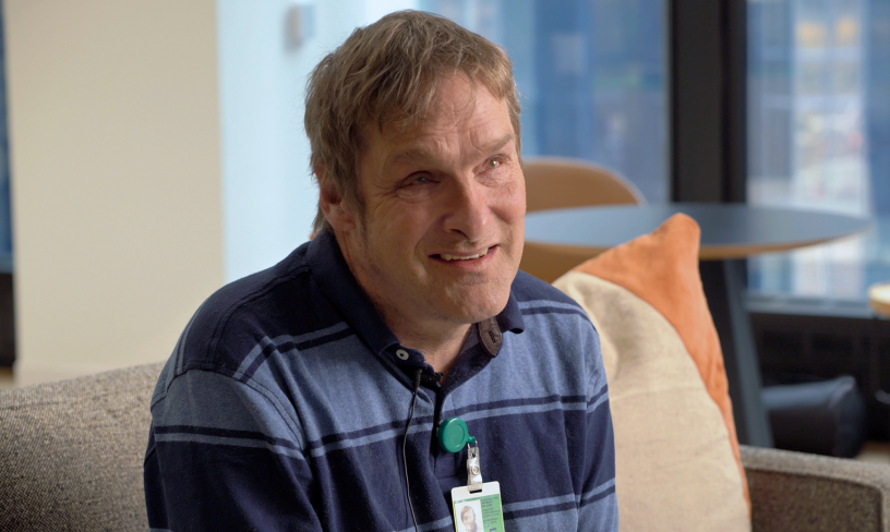 Brian Moore smiling while sitting on a couch